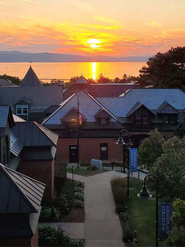 View of campus with the sun setting over the lake in the distance