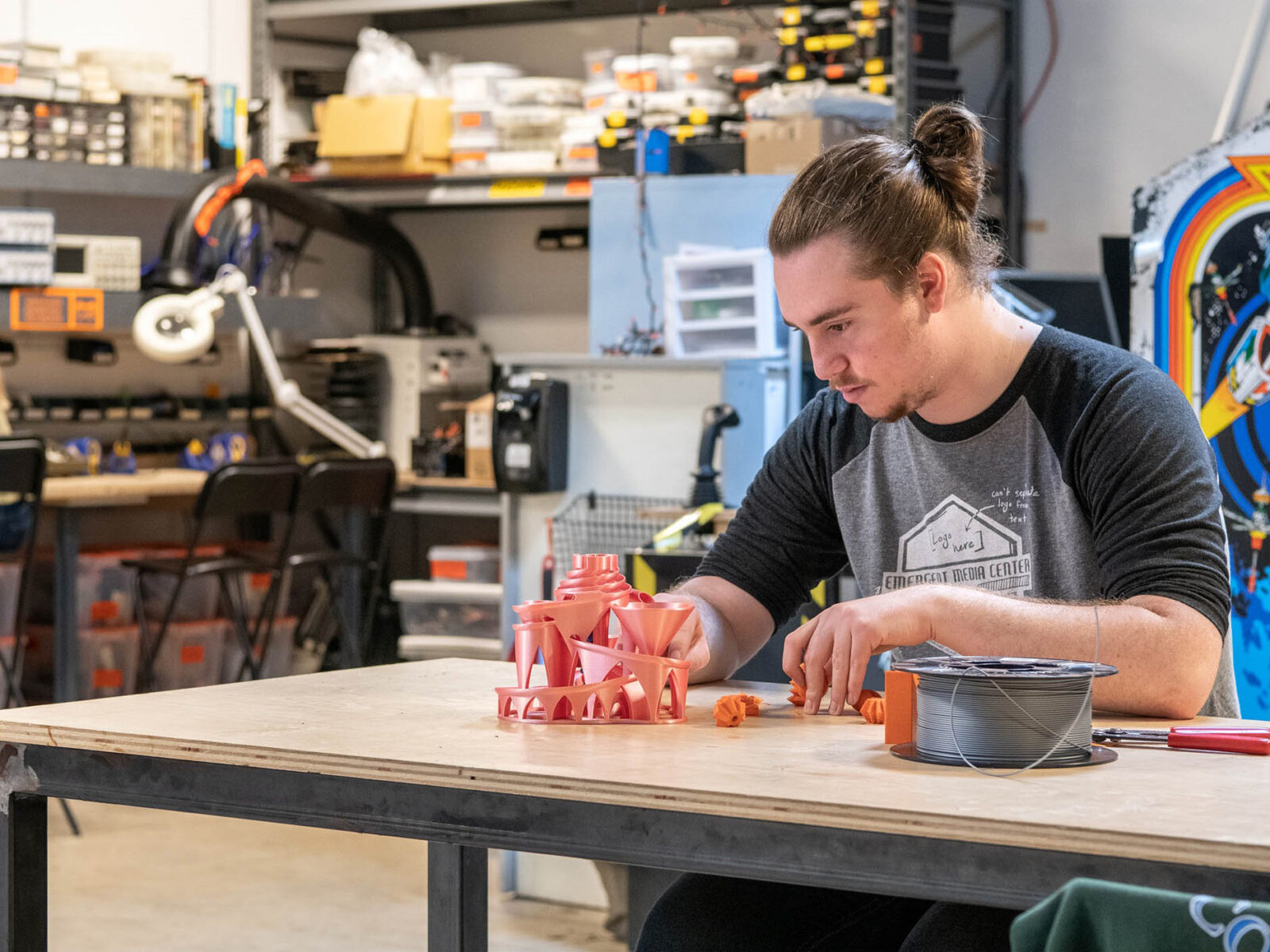 Student sitting at table working on assembling 3D printed components