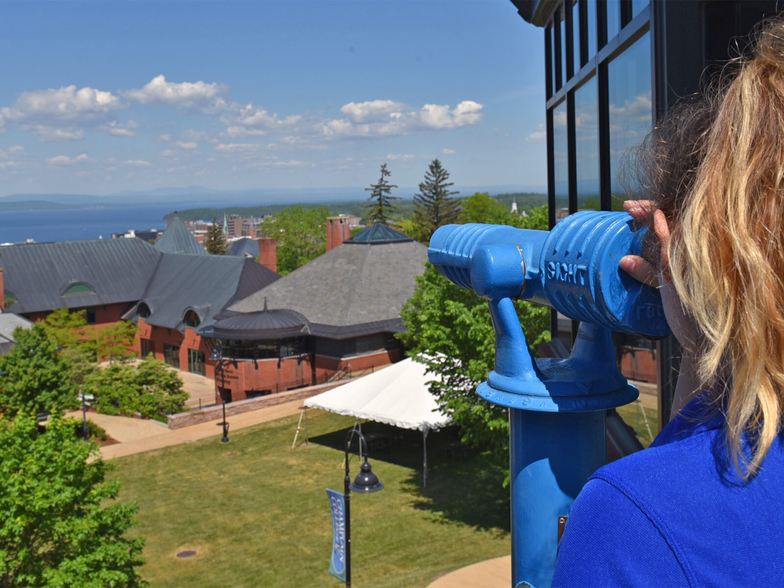 Student looking out at Lake Champlain through telescope on the library Terrace
