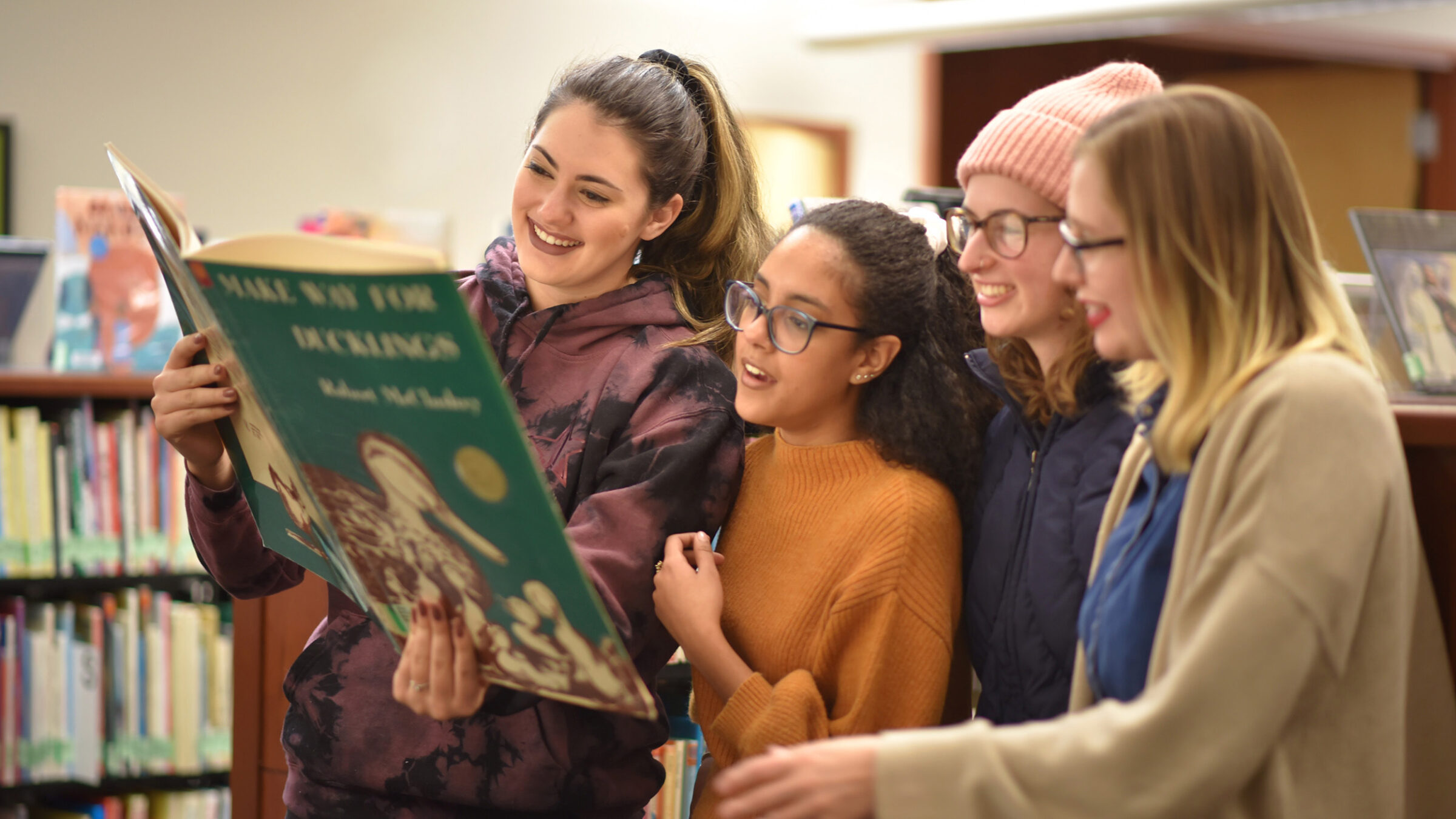 group of students looking at an oversized children's book