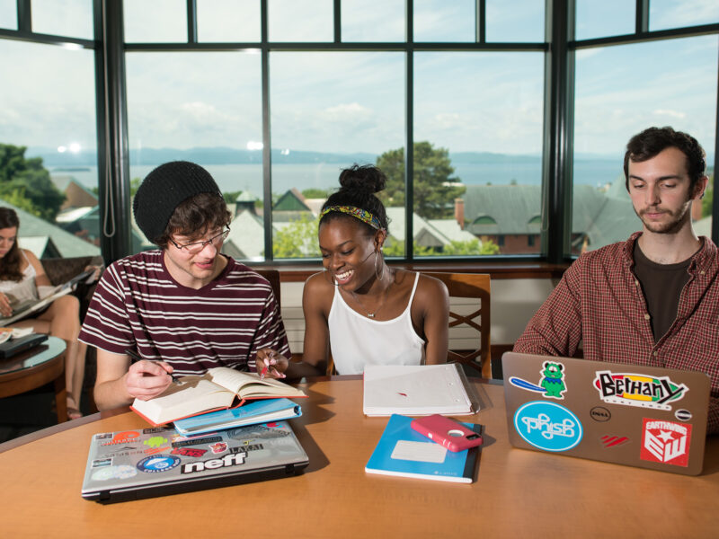 three students study together at a round table