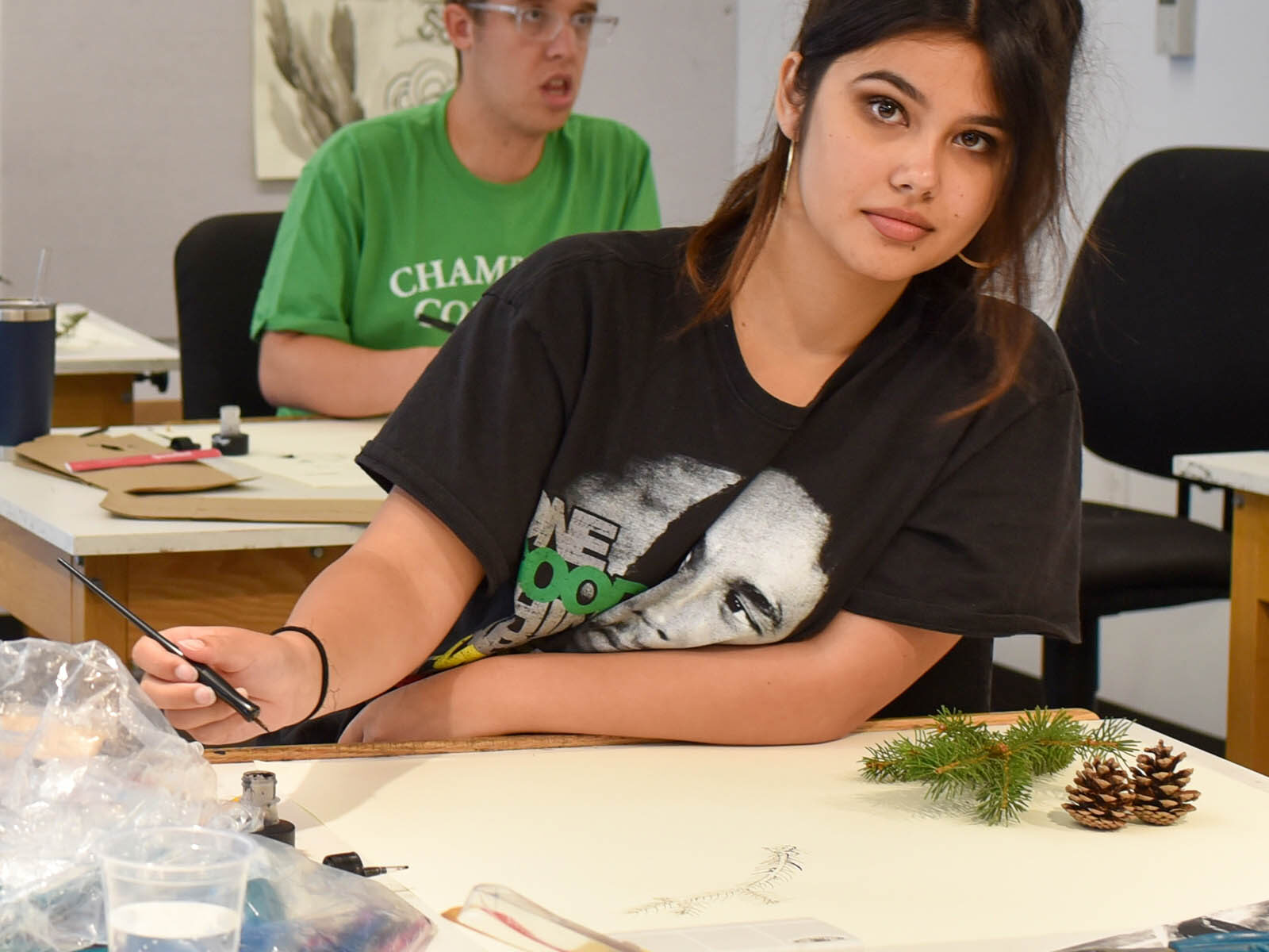 creative media student working on a painting using some foliage as a model