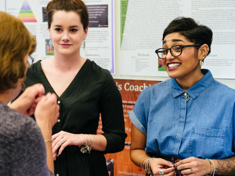 three students discussing and smiling