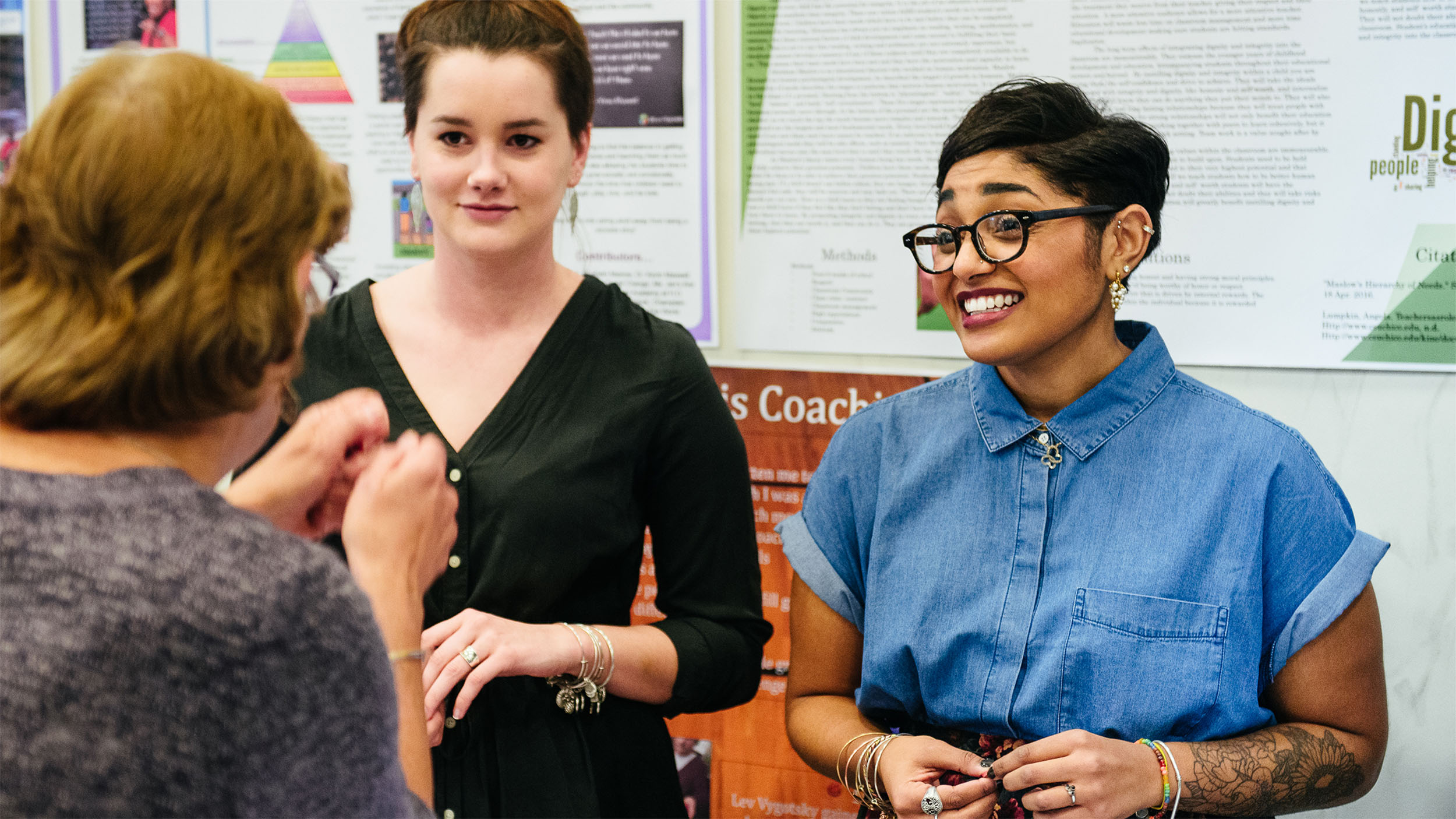 three students discussing and smiling