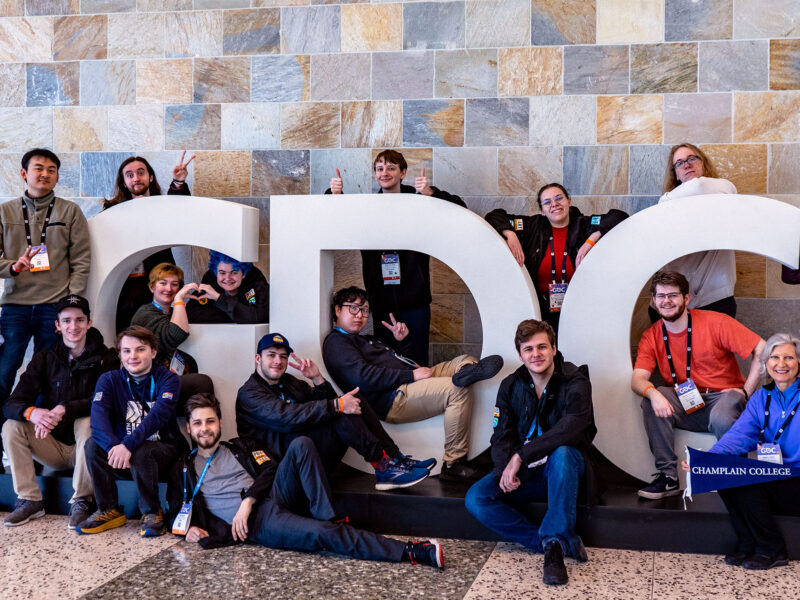 champlain college game studio students posing for a photo with the GDC sign at the game developers conference