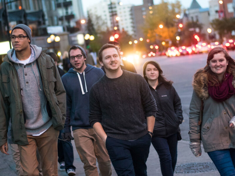 a group of students walk along the streets on Montreal during dusk