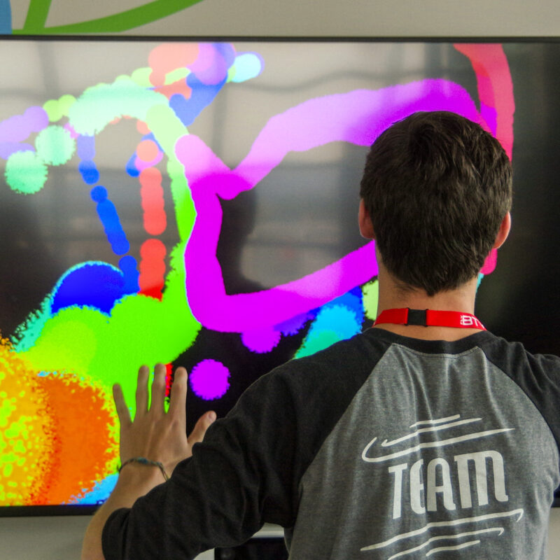student paints digitally on a tv screen
