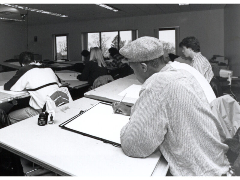Black and white photograph depicting students working at drafting tables in a drawing and design class at Champlain College.