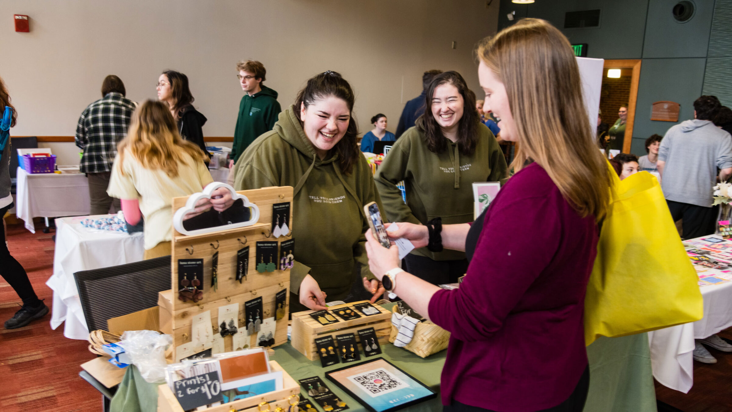 Two alumni sell earrings at the Champlain Weekend Market