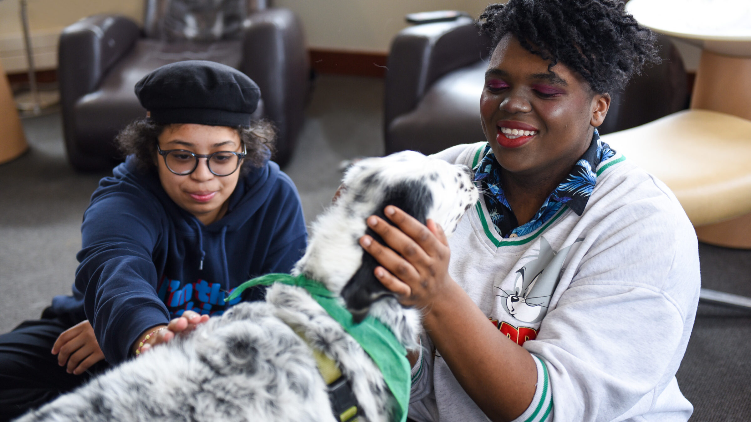 two students enjoys times with a therapy dog