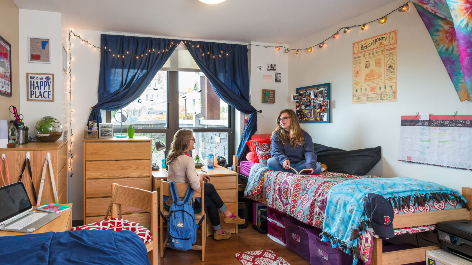 two roommates sitting in their dorm room having a conversation