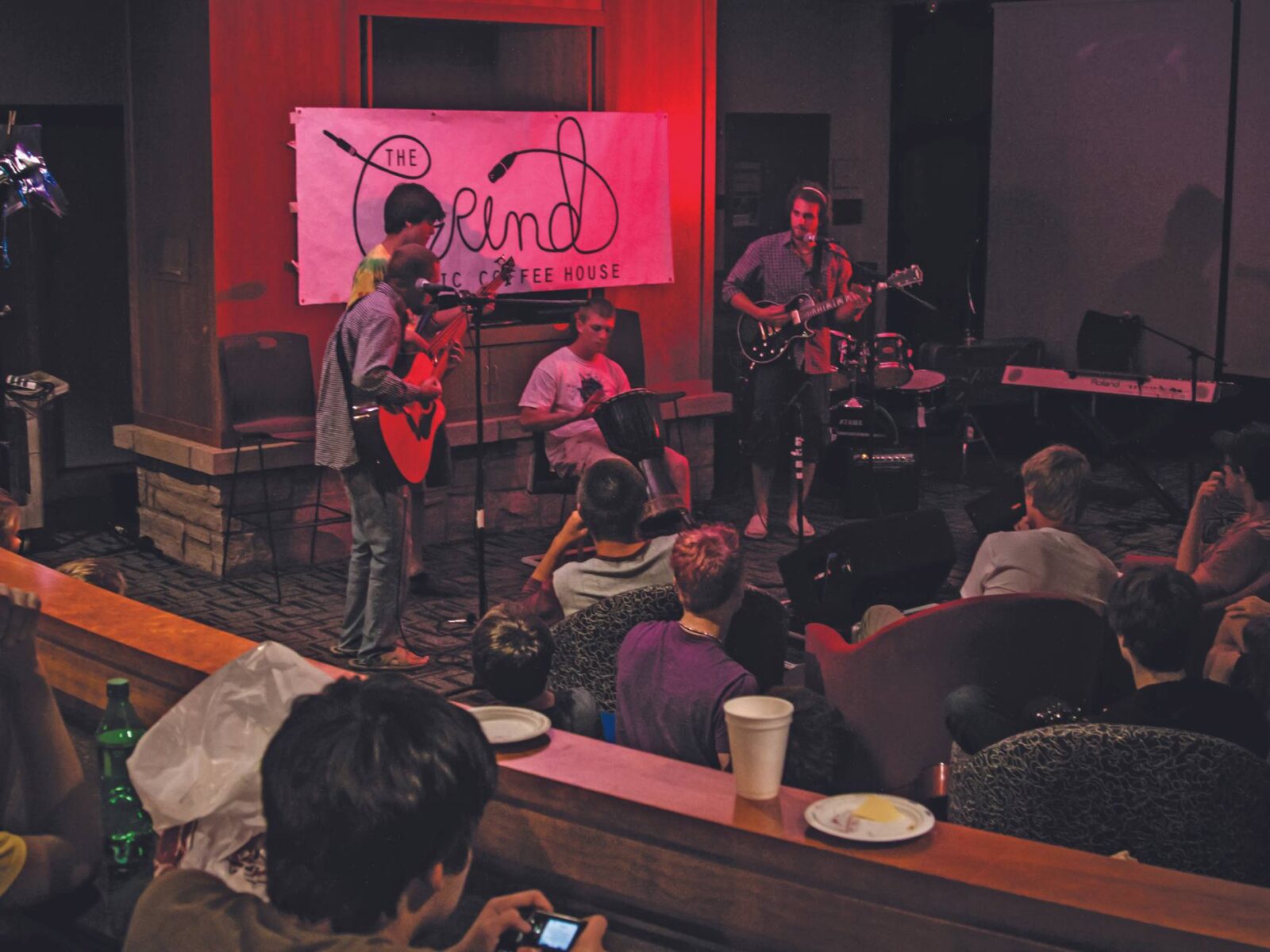 Students in fireside lounge preforming during The Grind with a red hue of light