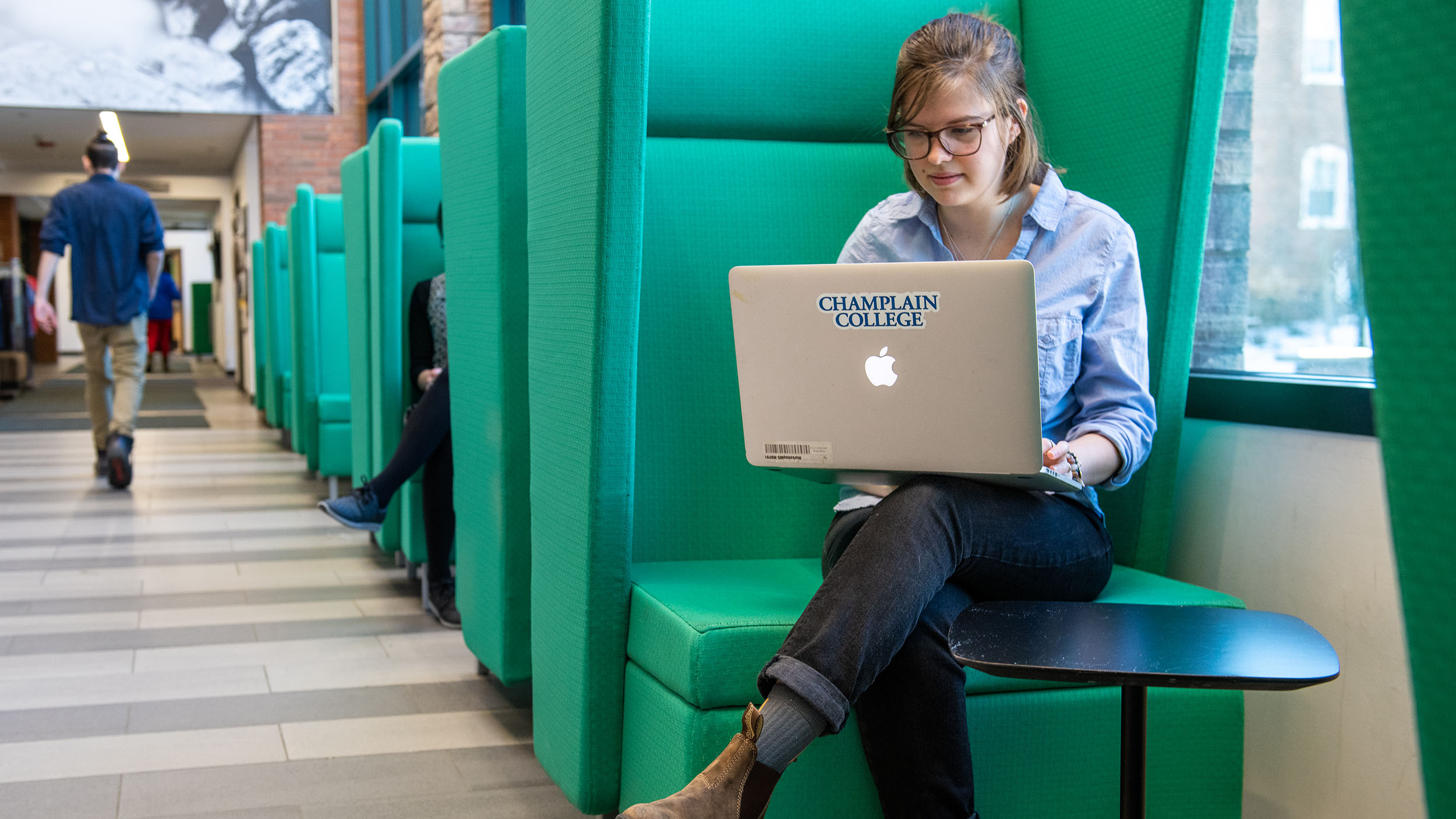 student in the CCM lounge working on their laptop