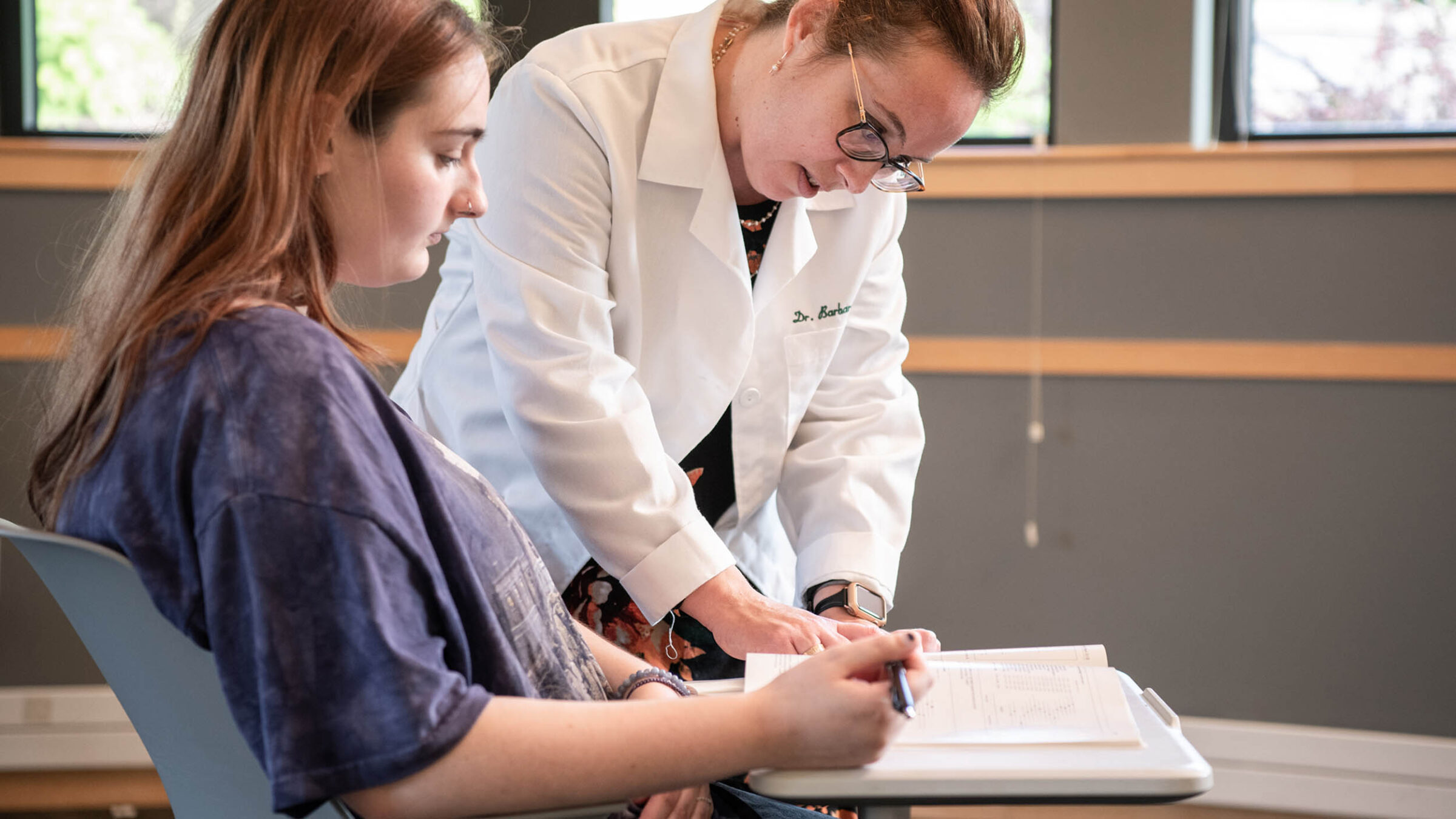 psychology professor assisting a student with their work