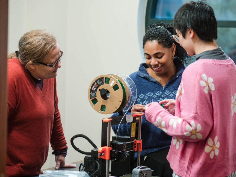 Students and an instructor working on a 3D printed project