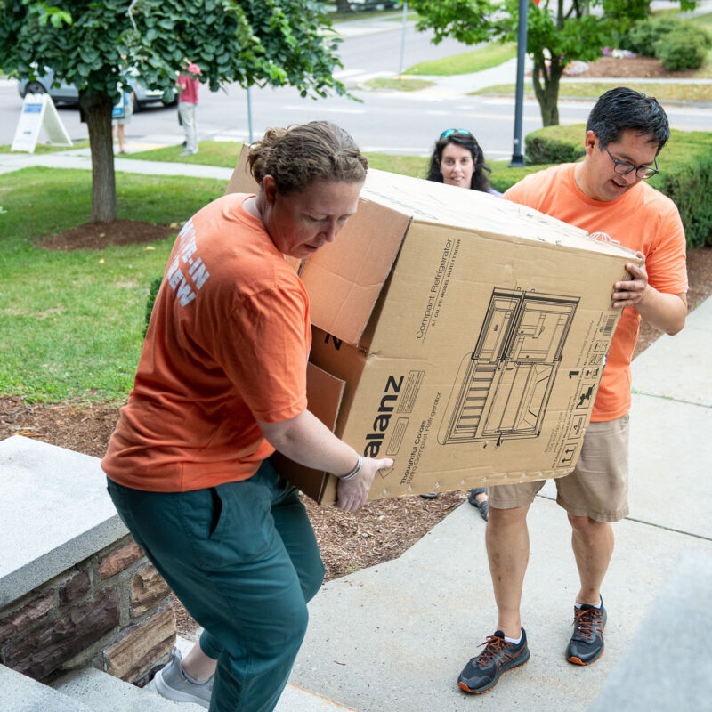 President Hernandez helps carry a box on move in day