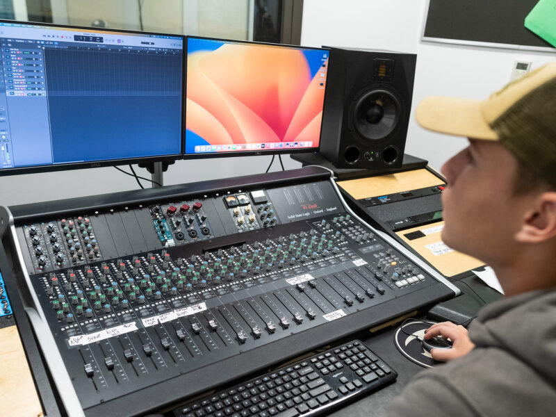 Student mixing audio using professional equipment