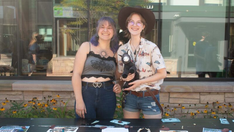 students in the equestrian club behind their table at the club and activities fair holding a stuffed horse smiling