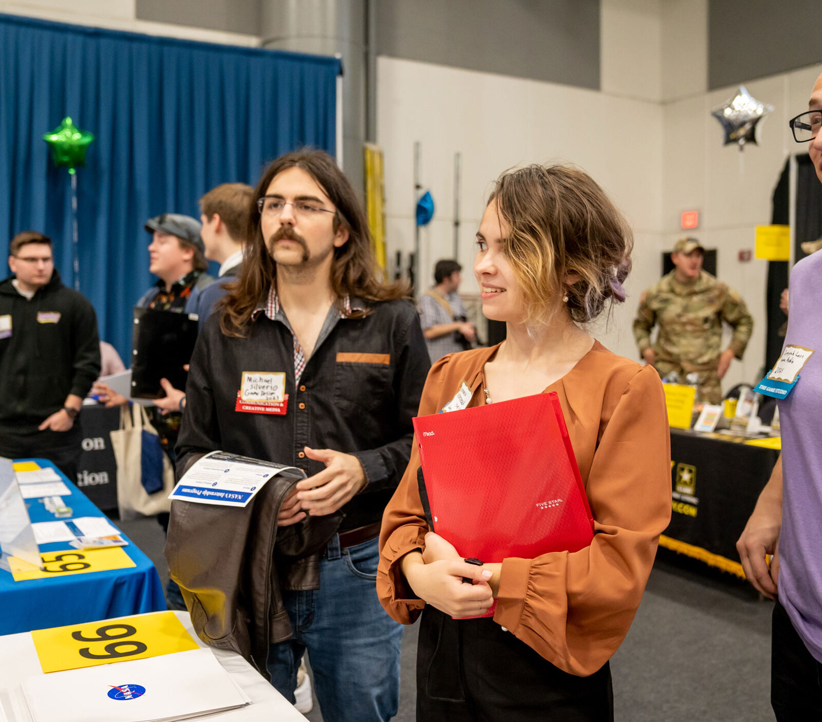 Three students stop to chat with a recruiter from NASA at the Career Fair.