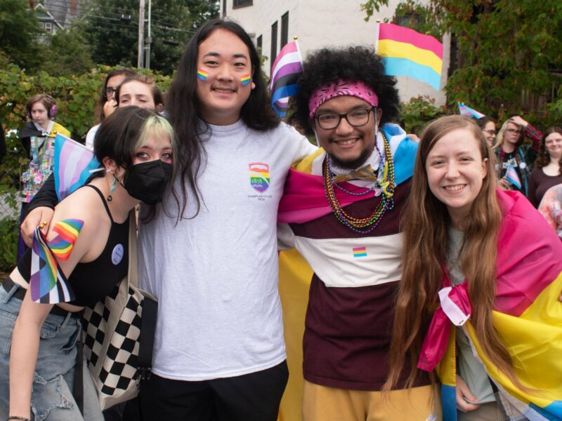 Group of students celebrating pride and posing with flags and face paint