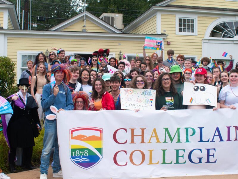 WGC Pride Parade student group photo with a Champlain College banner