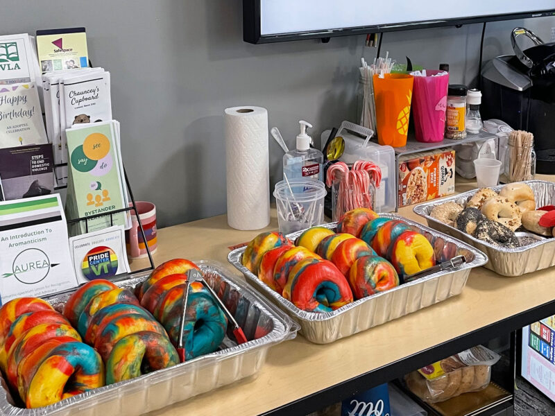 two trays of rainbow bagels sit on a table in the women's and gender center