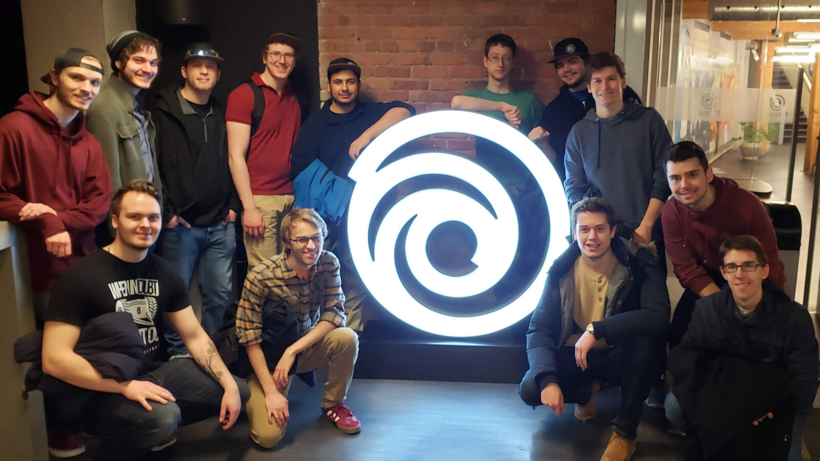 group of students pose around the Ubisoft logo