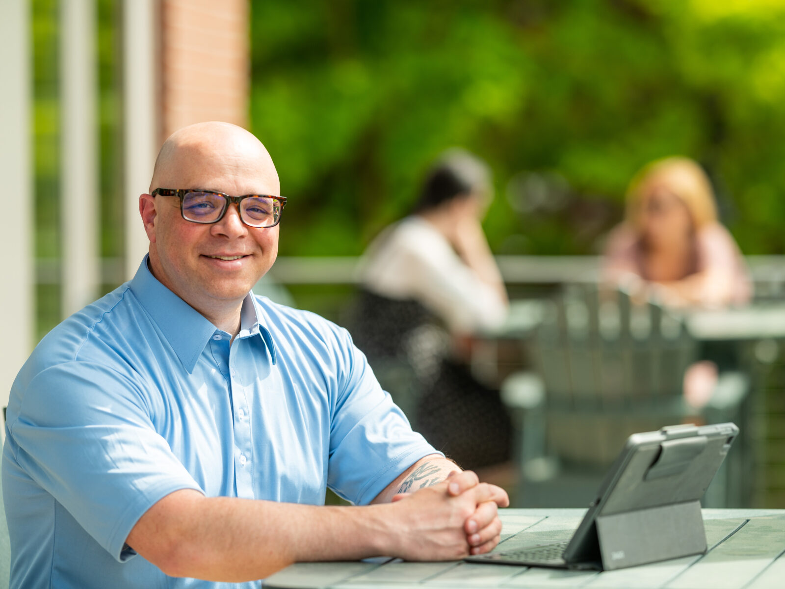 man at outdoor table using a laptop