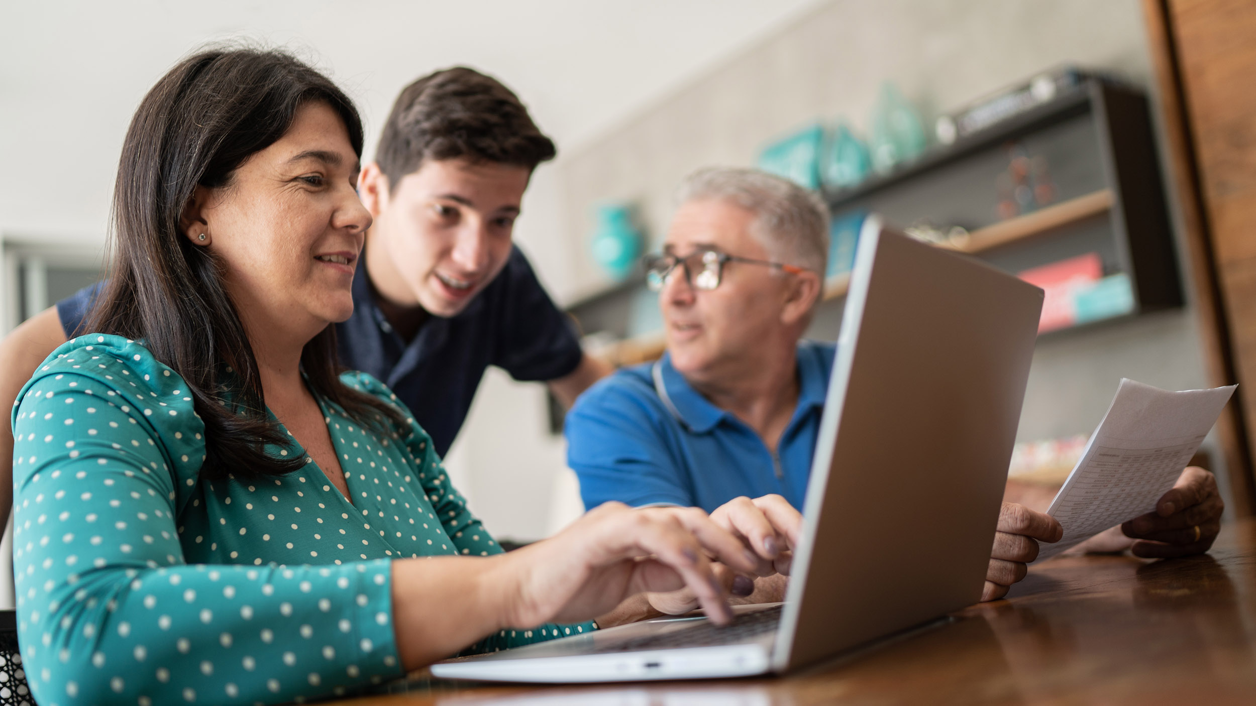 Parents doing home finances and talking to teenager son