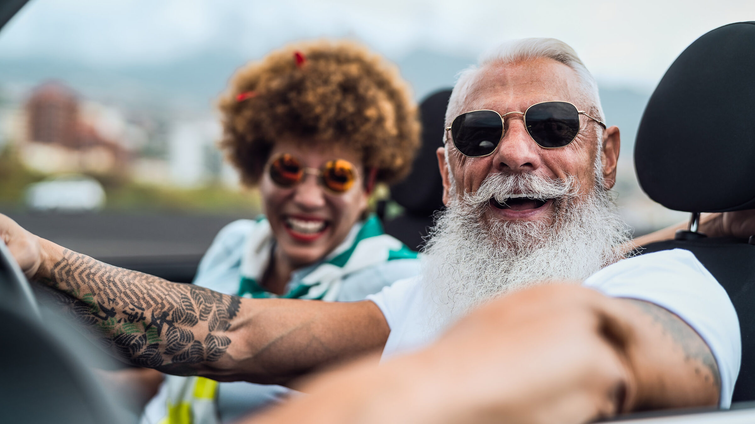 Mature couple having fun driving on new convertible car