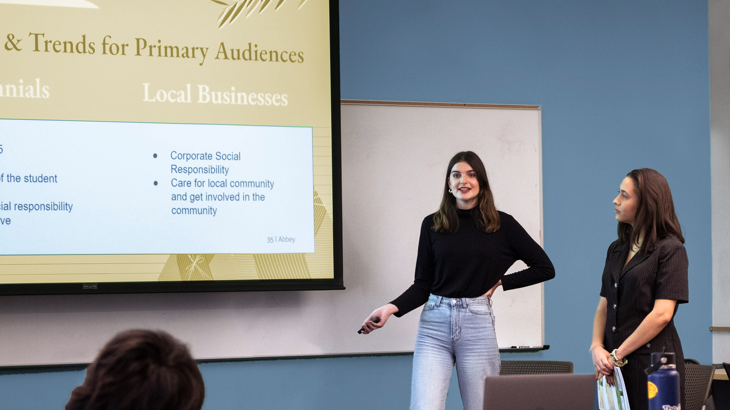 two students present at the front of the class