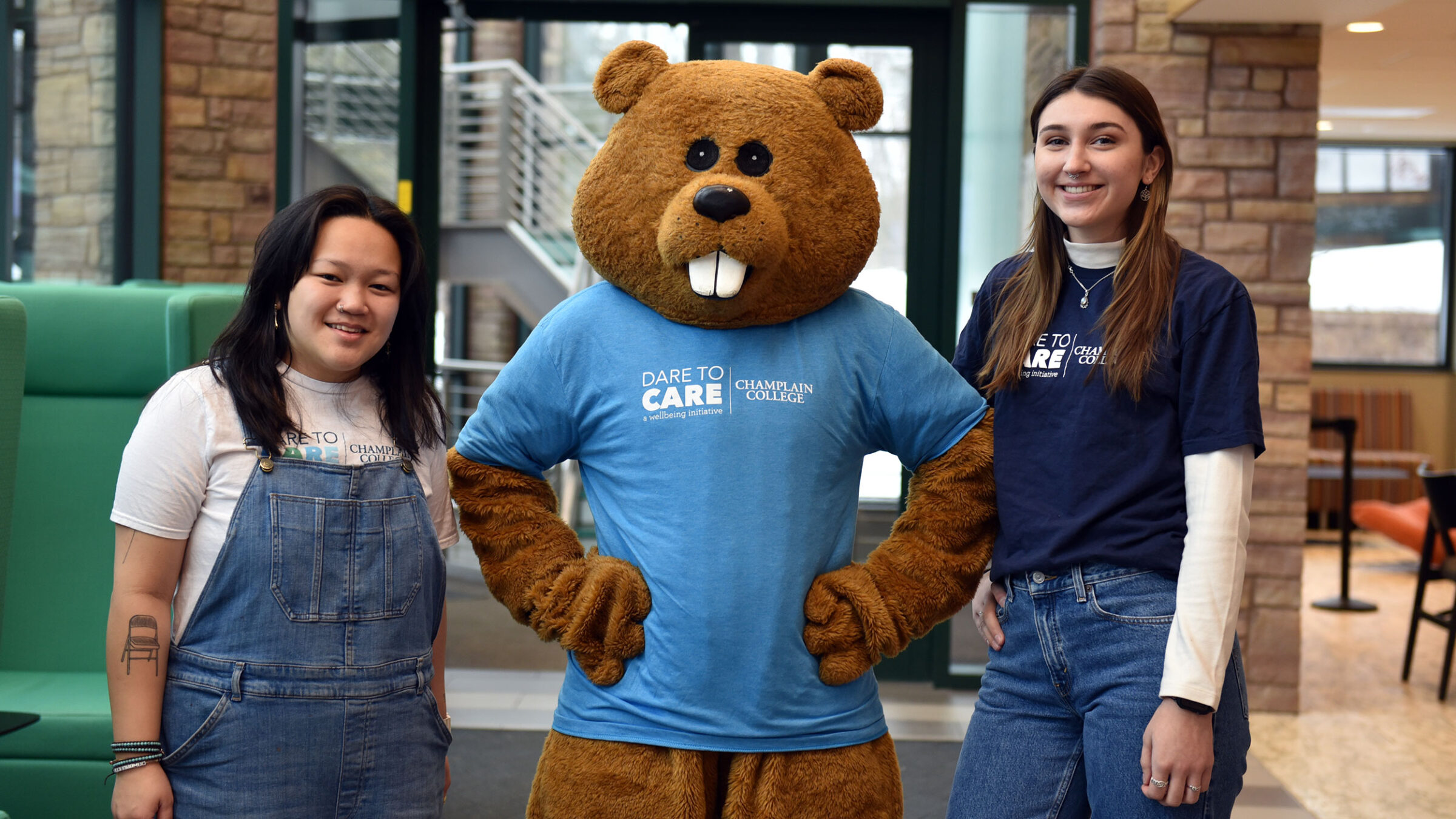 two students and chauncey smile for a photo, wearing their dare to care wellbeing t-shirts