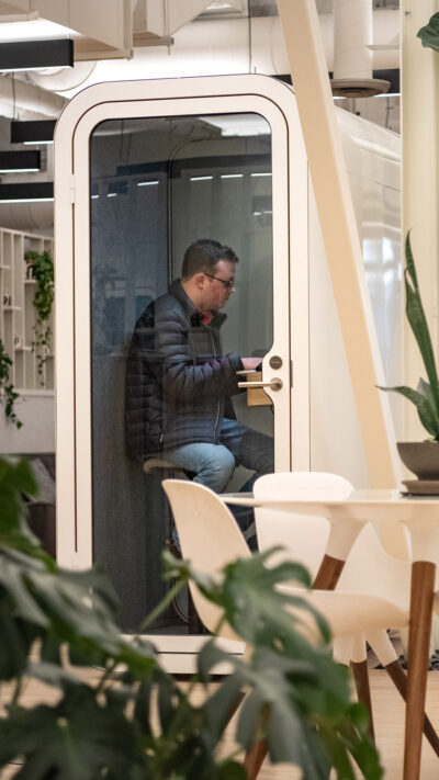 a person works inside a small booth so he can make a private virtual call