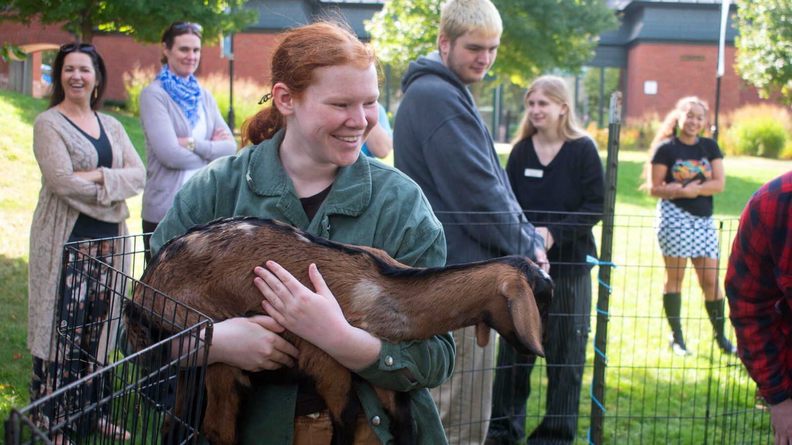 student holds a goat during a de-stress event