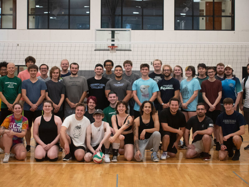 a group of 30 students pose for a team photo in argosy gym after a volleyball game