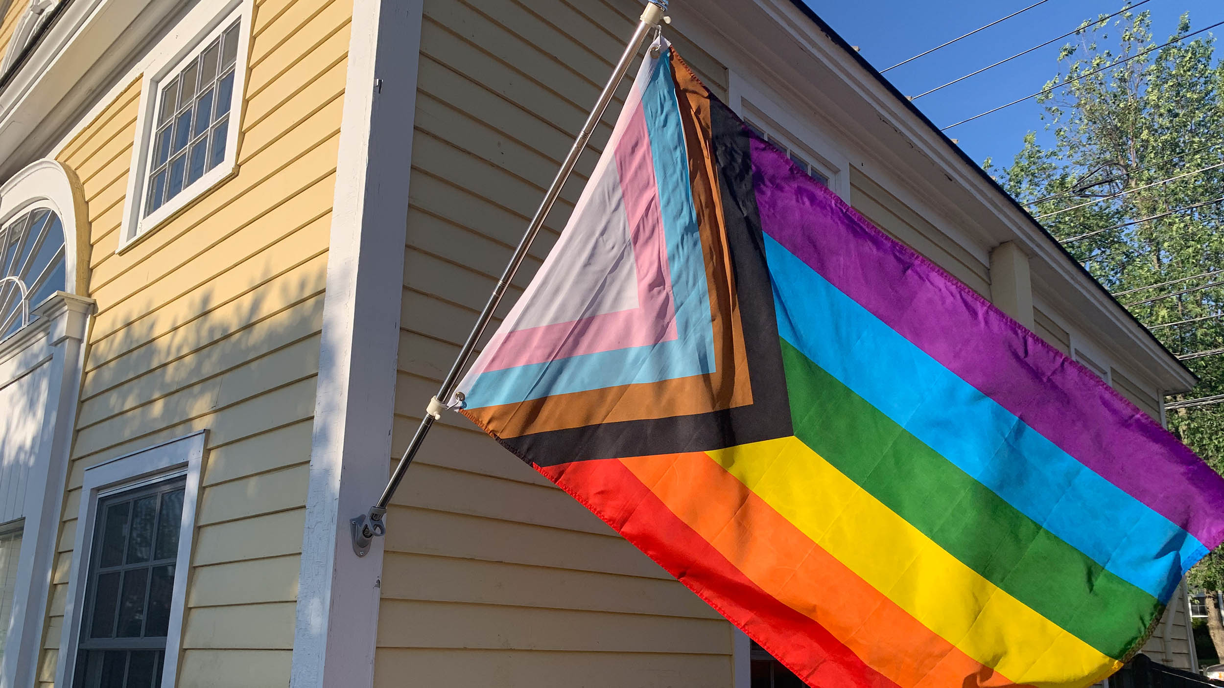 A pride flag hanging outside of Skiff Hall