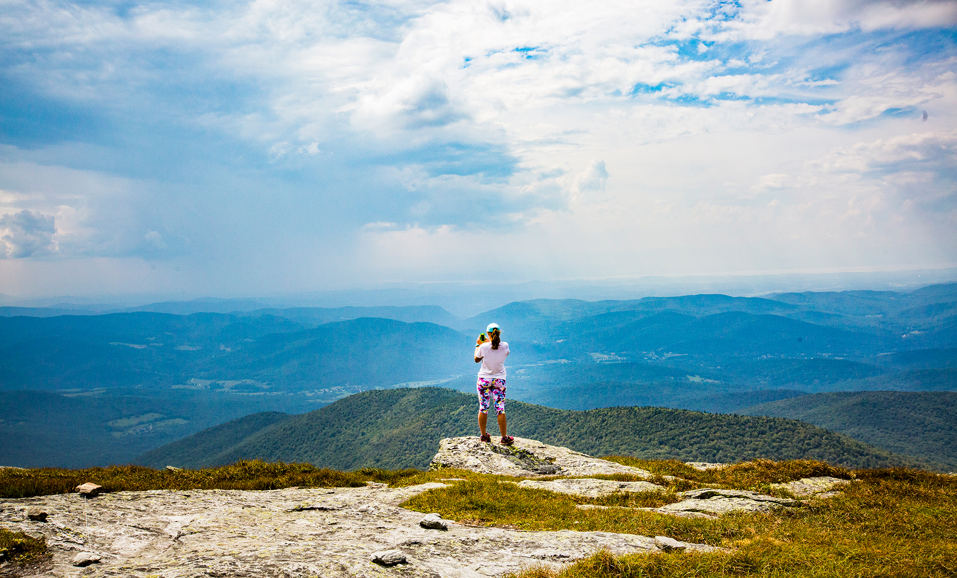 view from Camel's Hump, a person taking a photo of the landscape