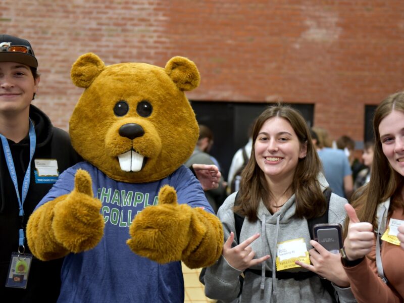 Three students and Chauncy the Beaver Mascot giving thumbs up signs at a career fair.