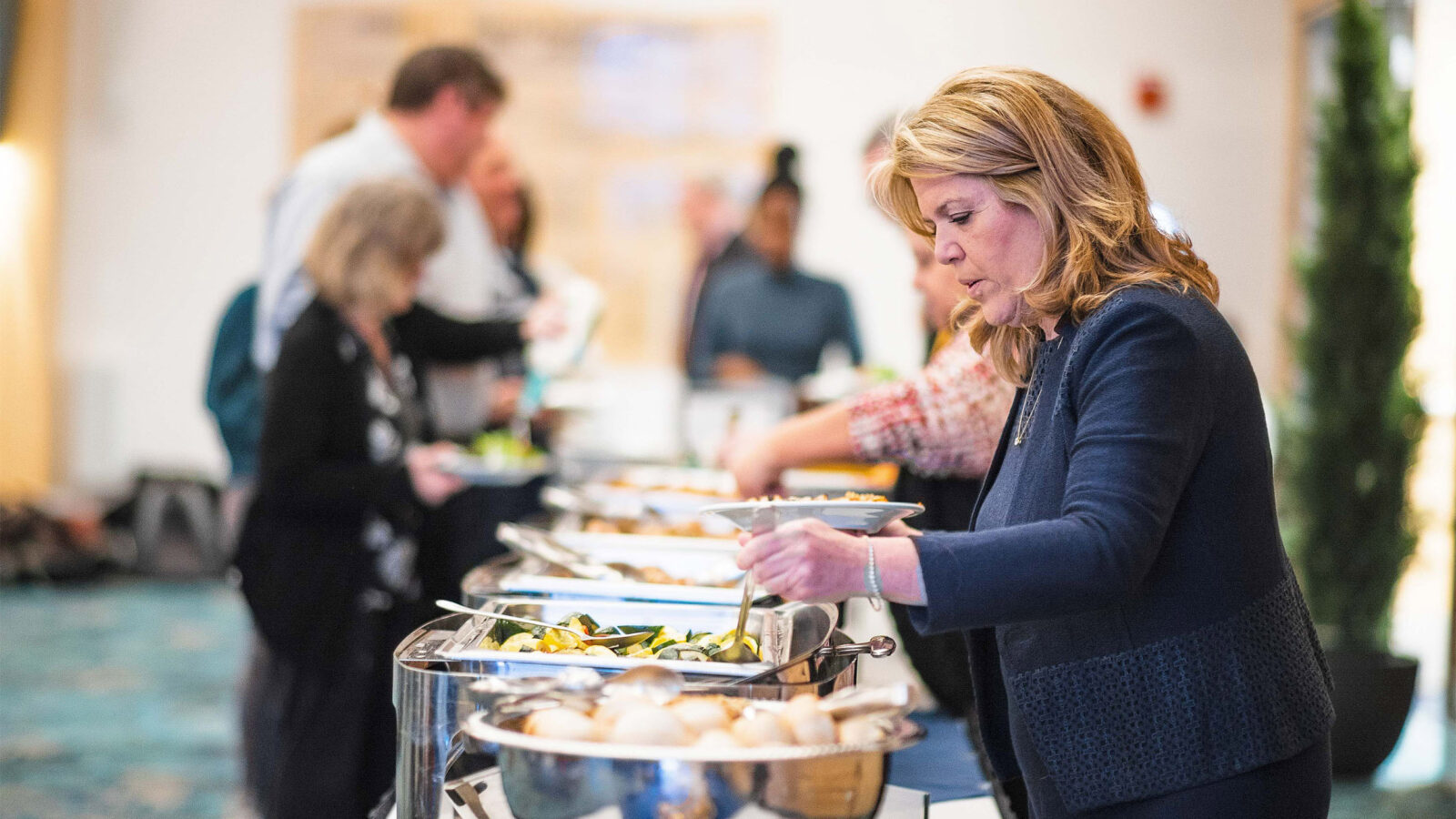 a staff member helping herself to the lunch bar at a catered event