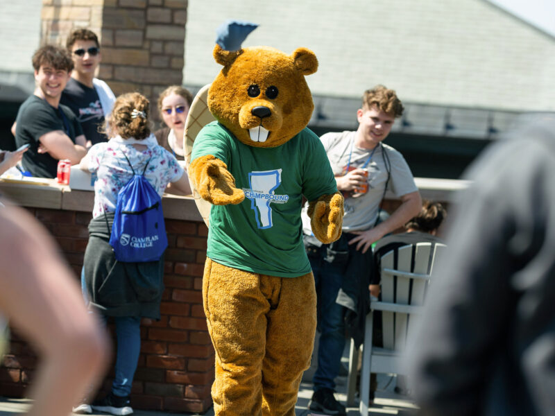 chauncey plays cornhole with admitted students outside on the terrace