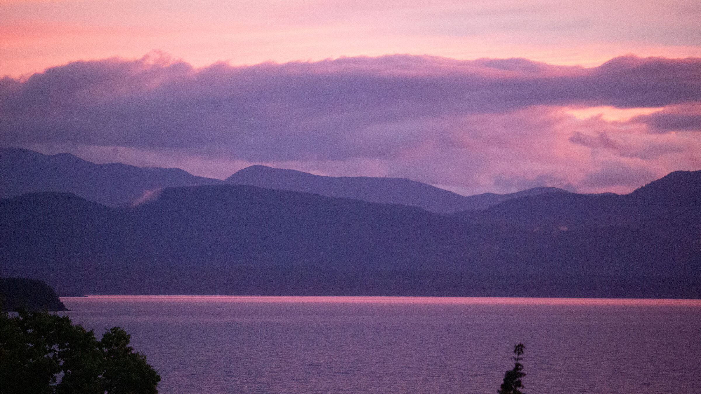 pink and purple hue on the mountains and lake champlain at sunset