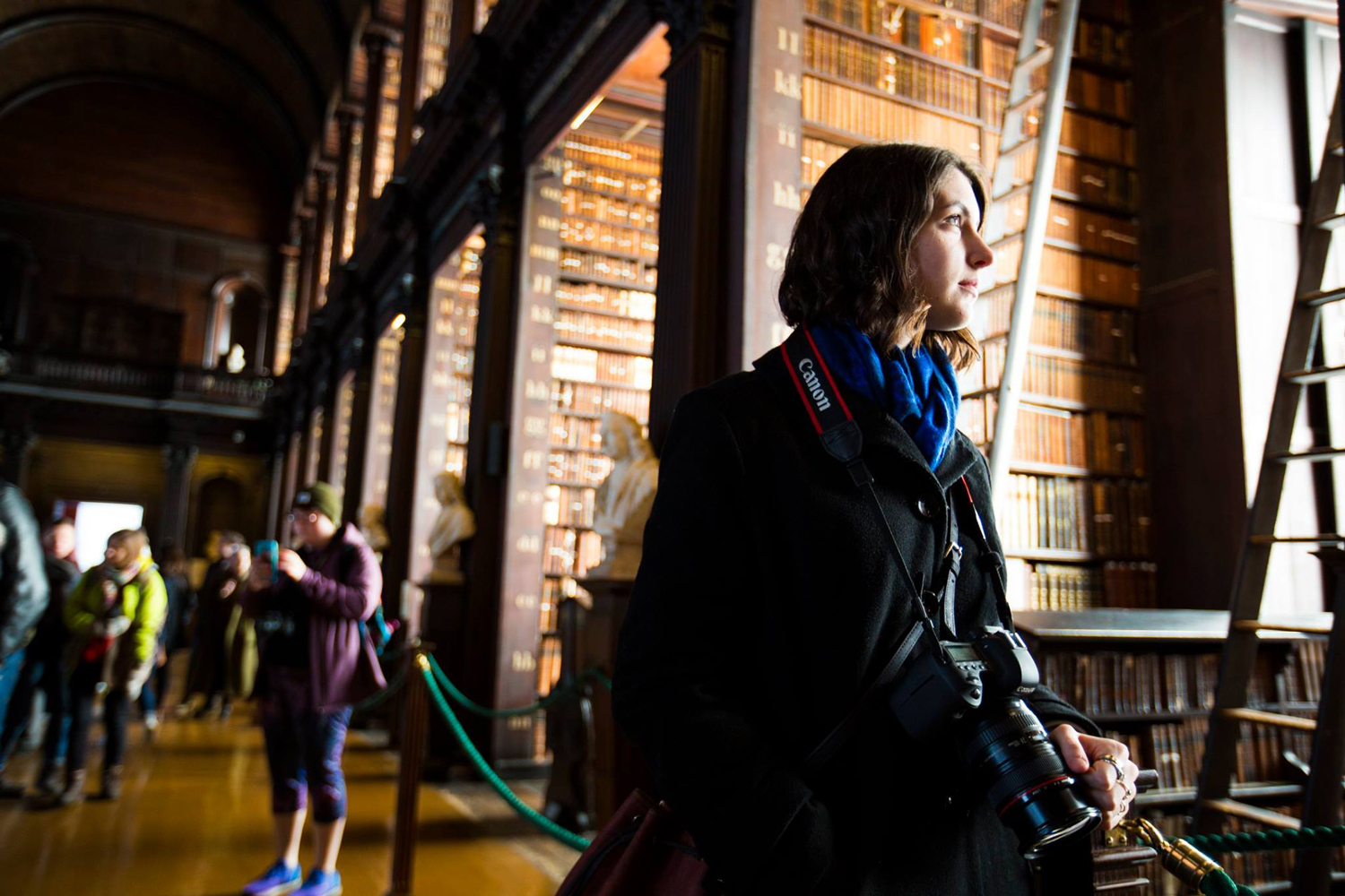 Student poses with a camera at Trinity University's library while studying abroad in Dublin. 