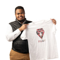 Ahmed Adan holds a t-shirt he made that says "FUAY"