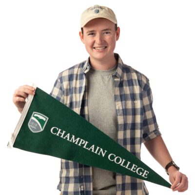 Wesley Beard holds a Champlain College flag
