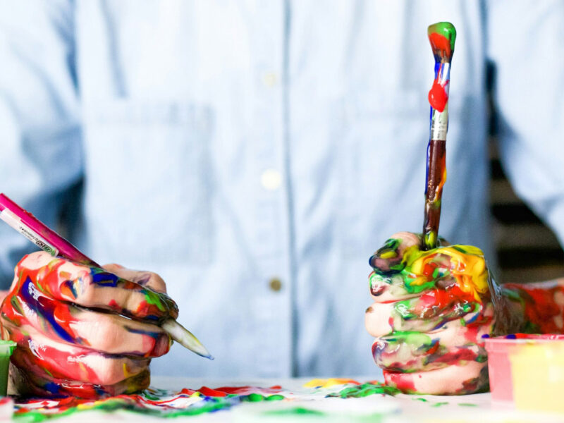 person's hands are covered in paint