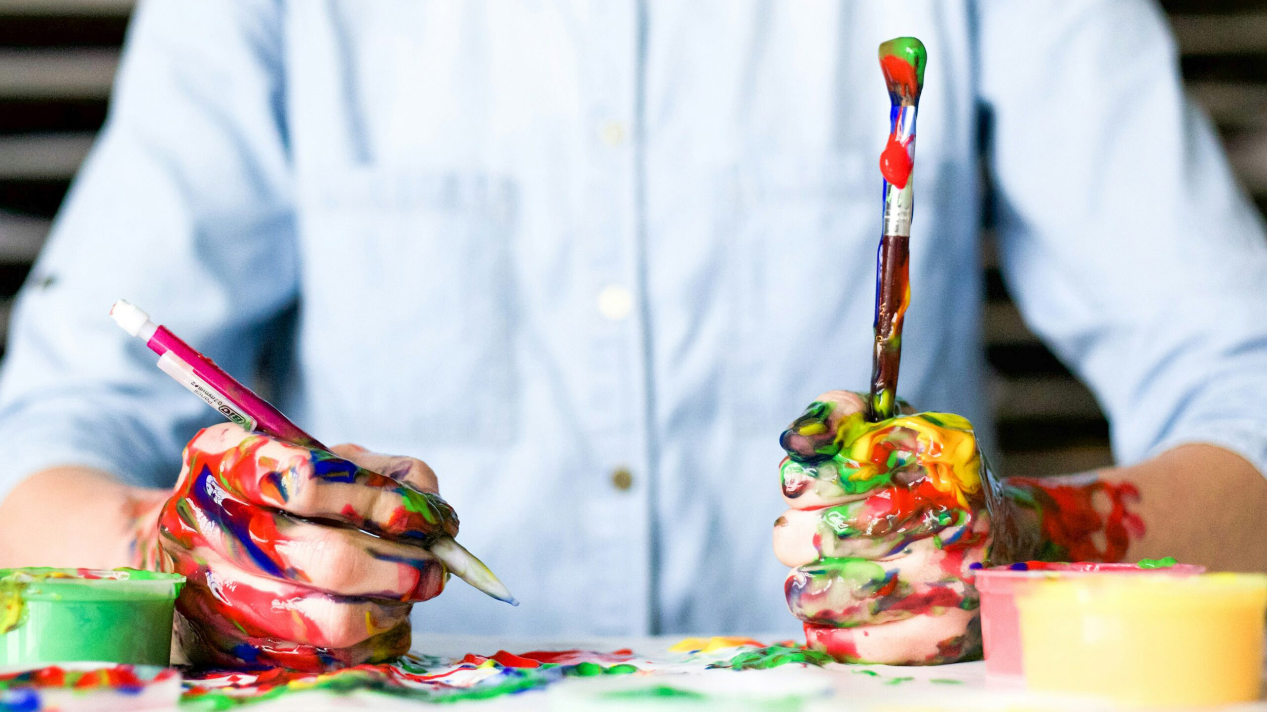 person's hands are covered in paint