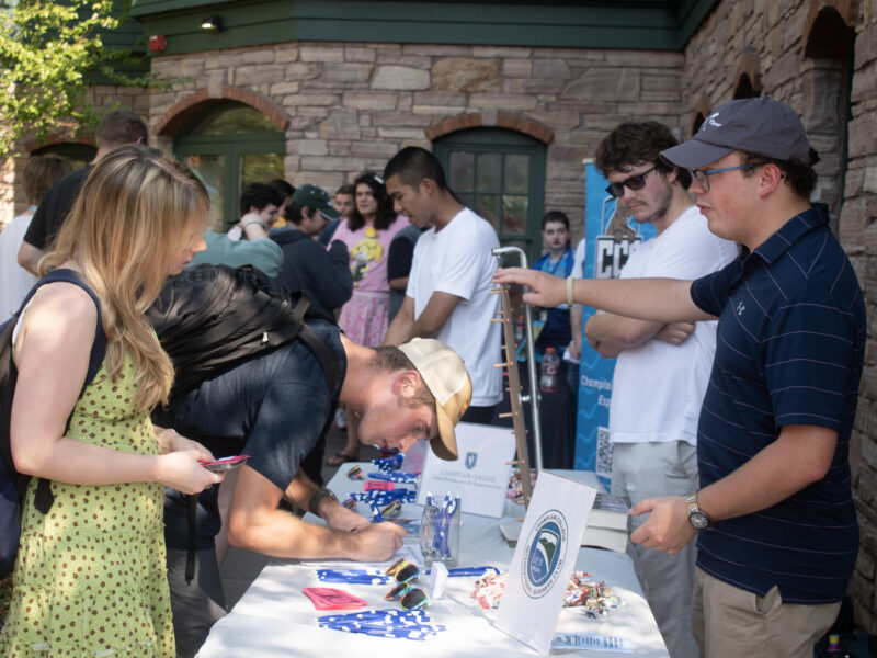 people talk to each other across a table outside at the activities fair