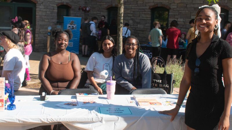 students in the black student union club posing for a photo during the fall activity fair in the courtyard