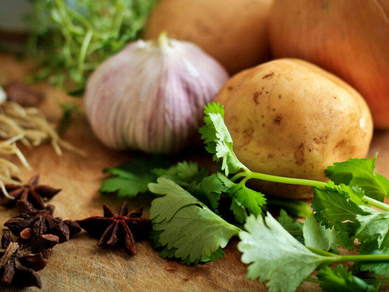 potato onion and parsley on a cutting board