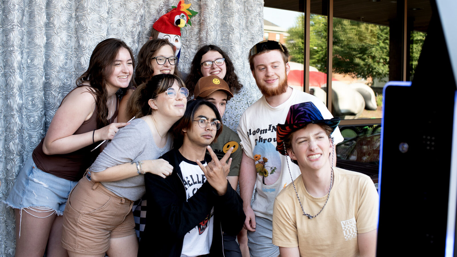 a group of student pose with pros and funny faces for a selfie